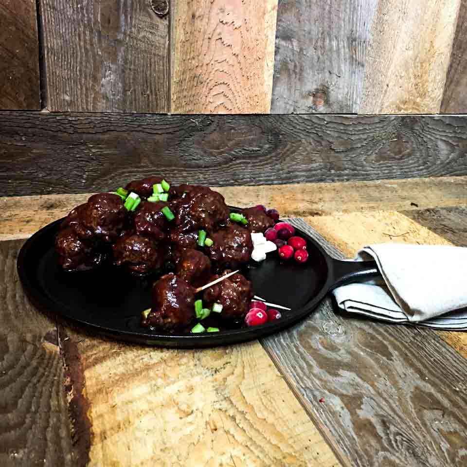 Crockpot cranberry chili meatballs displayed on a cast iron skillet