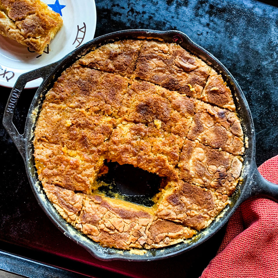 The easy pumpkin dump cake recipe, finished, with a slice cut and placed on a plate.