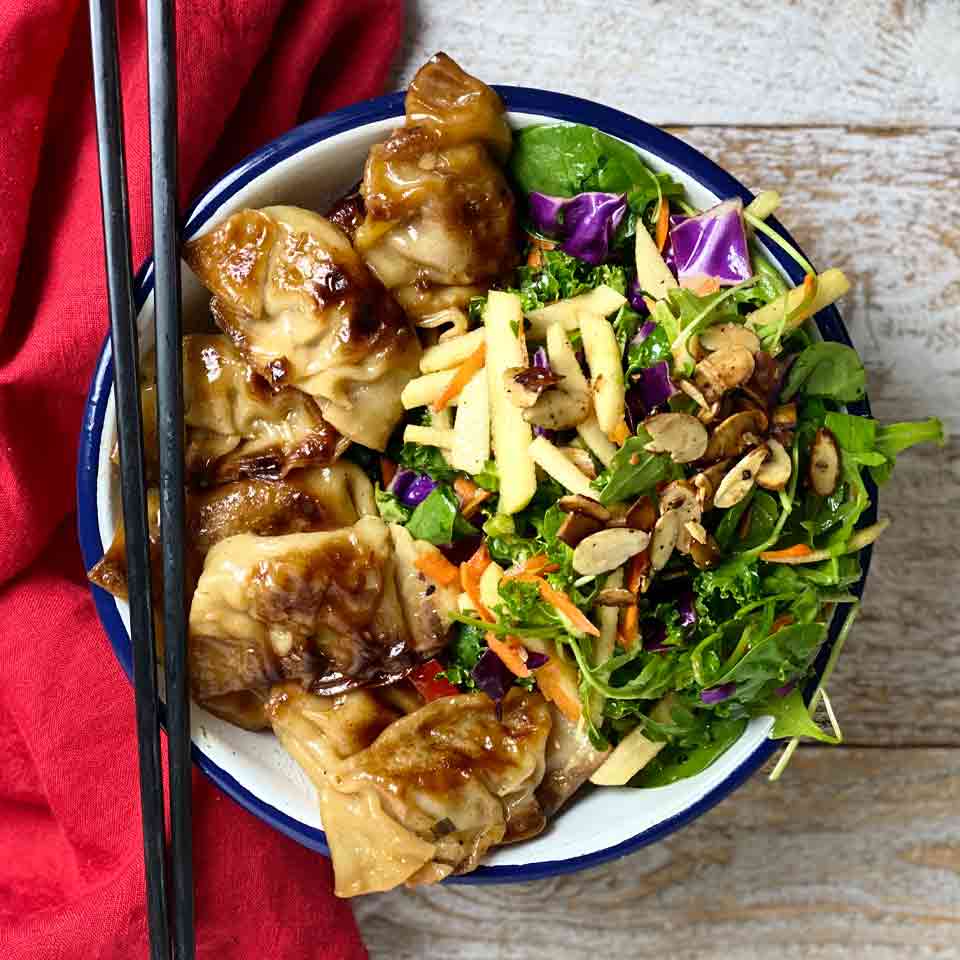 Homemade beef dumplings shown in a bowl with chopstix